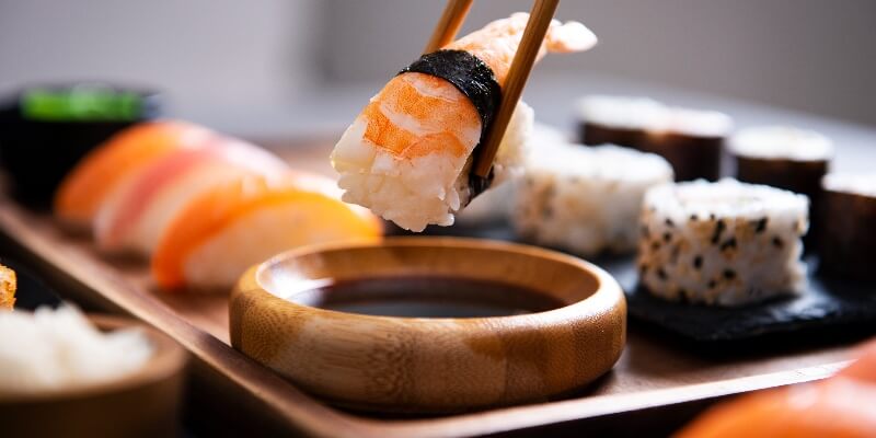 hand-dip-nigiri-shrimp-in-soy-sauce