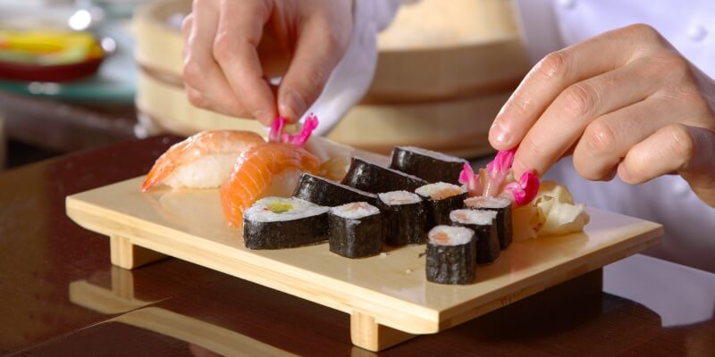 chef-preparing-sushi-on-wooden-get